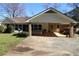 Rear exterior view of home featuring covered patio with a hot tub and well maintained landscaping at 575 Midland Park Dr, Stone Mountain, GA 30087