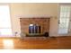Close-up of a brick fireplace with a white mantel and views of the yard at 575 Midland Park Dr, Stone Mountain, GA 30087