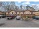 View of the home's exterior with Tudor-style details, parking spaces, mature trees, and landscaping at 3183 Abbeywood Dr, Decatur, GA 30034