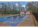 Outdoor pool with a pool house, covered in a blue tarp, surrounded by a fence and mature trees at 3183 Abbeywood Dr, Decatur, GA 30034