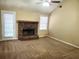 Inviting living room featuring a stone fireplace, carpet flooring, bright windows, and a door to the exterior at 130 Willow Shoals Dr, Covington, GA 30016