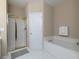 Bathroom featuring a shower with gold trim and a soaking tub with white tile surround at 132 Wetherbrooke Ln # 3, Smyrna, GA 30082