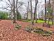 A tree-filled backyard with a stone creek bed and seating at 2751 Davis Rd, Marietta, GA 30062