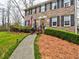 Brick facade with manicured shrubs leads to a welcoming red door, complete with address plaque and American flag at 2751 Davis Rd, Marietta, GA 30062