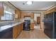 Traditional kitchen with stainless steel appliances, wooden cabinets, black refrigerator, and hardwood flooring at 921 Forest Park Ln, Suwanee, GA 30024