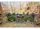 Relaxing backyard oasis with stone patio, fire pit, waterfront access, and beautiful landscaping at 100 Silverbell Ct, Roswell, GA 30075