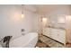 Bright bathroom features soaking tub, double vanity with marble counters and decorative light fixture at 100 Silverbell Ct, Roswell, GA 30075