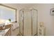 A bathroom featuring a glass-enclosed shower, tiled countertops, and a bright window at 100 Silverbell Ct, Roswell, GA 30075