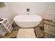 Stylish bathroom boasts modern soaking tub, patterned rug, neutral tile floor, and custom built-in shelves at 100 Silverbell Ct, Roswell, GA 30075