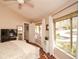 This bedroom offers a sunny window with white curtains and a view to the yard at 100 Silverbell Ct, Roswell, GA 30075