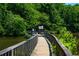 Wooden bridge extends into a lake, surrounded by lush greenery at 100 Silverbell Ct, Roswell, GA 30075