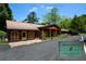 Charming home with a brown metal roof, wooden siding, stone accents, and a covered front porch at 100 Silverbell Ct, Roswell, GA 30075