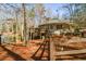 Exterior view of the house from the side with a wooden porch and mature trees and a wooden fence at 100 Silverbell Ct, Roswell, GA 30075