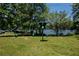 A playground with green equipment is set against a lake backdrop with ample play space at 100 Silverbell Ct, Roswell, GA 30075