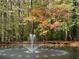 Picturesque pond scene with a fountain, surrounded by lush fall foliage and mature trees at 100 Silverbell Ct, Roswell, GA 30075