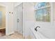 Bathroom features a white tub with an arched window, tiled shower, and wooden floors at 2778 Macland Rd, Dallas, GA 30157