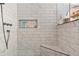 A modern shower featuring marble-like tiling, a built-in shelf, and sleek fixtures at 57 Forsyth Nw St # 14D, Atlanta, GA 30303