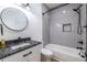 Modern bathroom featuring a black granite vanity, a shower-tub combo and neutral tile at 1466 Venetian Sw Dr, Atlanta, GA 30311