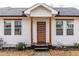 Close up of modern front door with wooden accents, white trim and a small porch at 1466 Venetian Sw Dr, Atlanta, GA 30311
