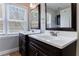 Well-lit bathroom featuring double sink vanity with espresso wood cabinets and a large window at 3044 Windfield Cir, Tucker, GA 30084