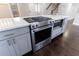 Close up of kitchen island with oven, cooktop, microwave, and white countertop at 3044 Windfield Cir, Tucker, GA 30084