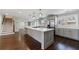 Bright kitchen with stainless steel appliances, gray cabinets, island, hardwood floors, and a nearby staircase at 3044 Windfield Cir, Tucker, GA 30084
