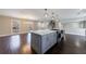 Kitchen with marble countertops, stainless steel appliances, gray cabinets, island, and wood floors at 3044 Windfield Cir, Tucker, GA 30084