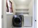 Bright laundry room with a modern washer and dryer and shelving above at 3044 Windfield Cir, Tucker, GA 30084