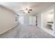 Spacious main bedroom with neutral walls, gray carpet, and entrance to en suite bathroom at 3044 Windfield Cir, Tucker, GA 30084
