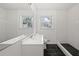 Modern bathroom with subway tile, black honeycomb floor in shower, and vanity with two windows at 3648 Garrison Sw Dr, Atlanta, GA 30331