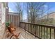 Cozy balcony with two wooden chairs, a small side table, and a view of the surrounding trees at 145 Rose Garden Ln, Alpharetta, GA 30009