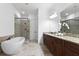 A luxurious bathroom with a modern tub, glass shower, and dual vanity with granite counters at 145 Rose Garden Ln, Alpharetta, GA 30009