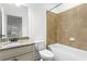 A well-lit bathroom featuring a vanity with granite countertop and a tiled shower over tub at 145 Rose Garden Ln, Alpharetta, GA 30009