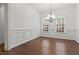 Elegant dining room with wainscoting, chandelier lighting, and hardwood floors at 145 Rose Garden Ln, Alpharetta, GA 30009