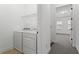 A bright laundry room featuring a washer and dryer with an adjacent doorway at 145 Rose Garden Ln, Alpharetta, GA 30009