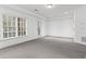 A bright living room with neutral carpet, white walls, and windows offering natural light at 145 Rose Garden Ln, Alpharetta, GA 30009