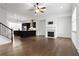 Open-concept living room with hardwood floors, fireplace, and modern kitchen view at 145 Rose Garden Ln, Alpharetta, GA 30009