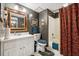 Vintage bathroom featuring a white vanity, patterned wallpaper, ornate mirror, and patterned shower curtain at 2595 Ross Rd, Snellville, GA 30039