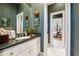 Charming bathroom with green patterned wallpaper, white cabinets, and a view of a bedroom beyond at 2595 Ross Rd, Snellville, GA 30039