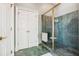 Elegant bathroom featuring a glass shower, green marble tiling, and a white double-door closet at 2595 Ross Rd, Snellville, GA 30039