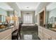 Elegant bathroom with dual vanities, a soaking tub, marble floors, and plantation shutters at 2595 Ross Rd, Snellville, GA 30039