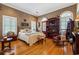 Cozy bedroom with hardwood floors, natural wallpaper, wooden furniture, and windows with white shutters at 2595 Ross Rd, Snellville, GA 30039