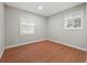 This bedroom features hardwood floors, two windows for natural light, and neutral wall paint at 6605 Black Bend Ct, Riverdale, GA 30274