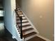 View of the staircase with stained wood treads and white risers and stringers at 738 Basswood Ave, Mcdonough, GA 30252