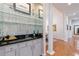 Stylish home bar featuring elegant glass shelving, mirrored backsplash, and granite countertop, perfect for entertaining guests at 3101 Howell Mill Nw Rd # 327, Atlanta, GA 30327