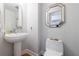 Charming powder room featuring a pedestal sink, decorative mirror, and patterned wallpaper at 3101 Howell Mill Nw Rd # 327, Atlanta, GA 30327
