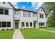 Charming new construction townhomes with white brick and siding, complemented by lush green lawns and professional landscaping at 1322 Parc Bench Rd, Atlanta, GA 30316