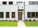 Close up view of townhome featuring white brick, dark trim, and well manicured lawn leading to the front door at 1322 Parc Bench Rd, Atlanta, GA 30316