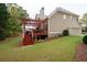 Backyard featuring a wood deck, mature trees, and lush green lawn at 4651 Oakleigh Manor Dr, Powder Springs, GA 30127