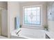Bright bathroom featuring a jacuzzi tub with a decorative patterned window at 4651 Oakleigh Manor Dr, Powder Springs, GA 30127